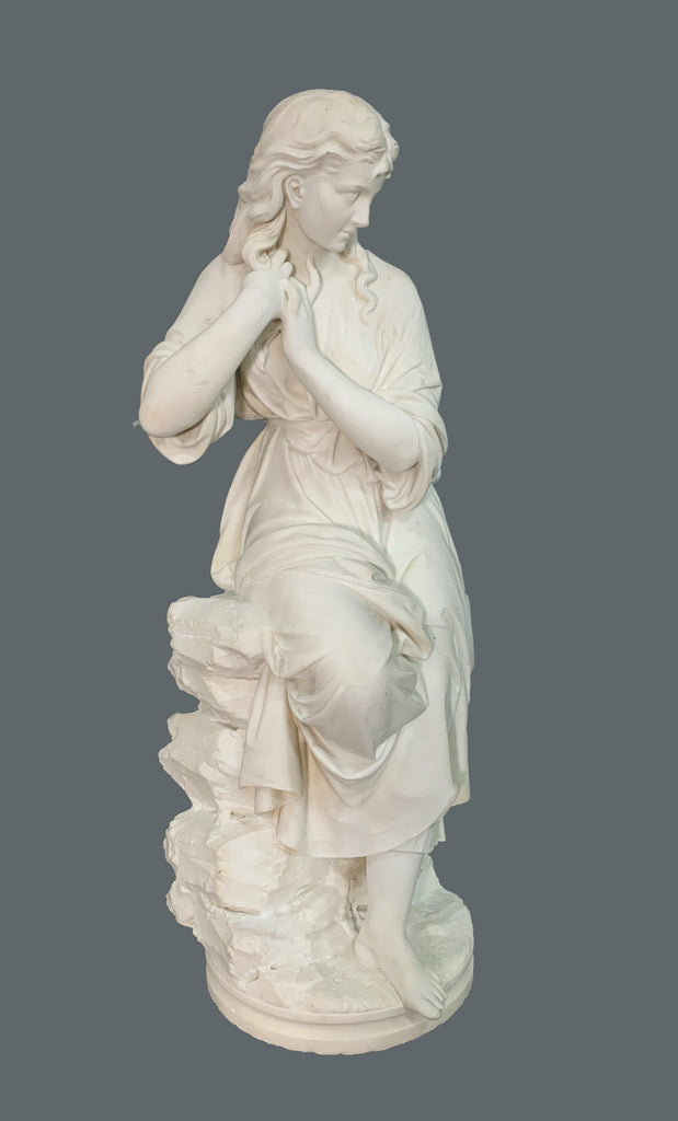 marble figure of a lady sitting on rocks
