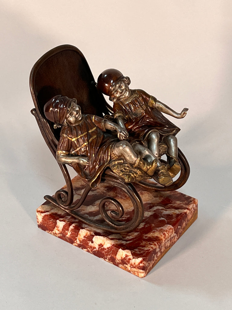 Bronze group of children on rocking chair by chiparus